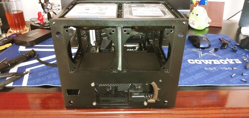 This is the mod that made the entire build possible.  The Node 304 was originally meant for an ATX power supply mounted sideways within the chassis.  I knew I wanted to move to an SFX PSU to open up some room, and originally was intent on just mounting sideways until this idea hit me like a ton of bricks, and it was suddenly game on.  

Took some work to cleanly locate and cut the front of the case, and I had to modify it after I decided to buy another main power cable with a better orientation.  Done again I'd leave a strip along the right and get the 4th bolt in, and open up a smaller lower hole for a pass through.